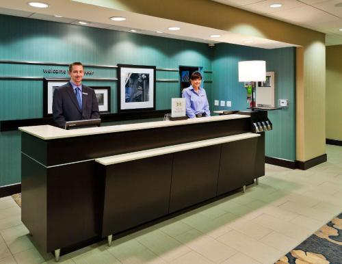 two men standing at a counter in a hospital lobby at Hampton Inn & Suites Denver Airport / Gateway Park in Aurora