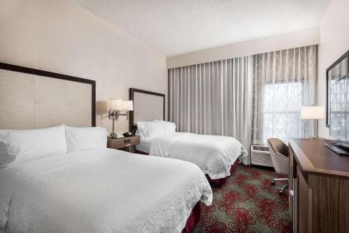 a hotel room with two beds and a desk at Hampton Inn Debary-Deltona in DeBary