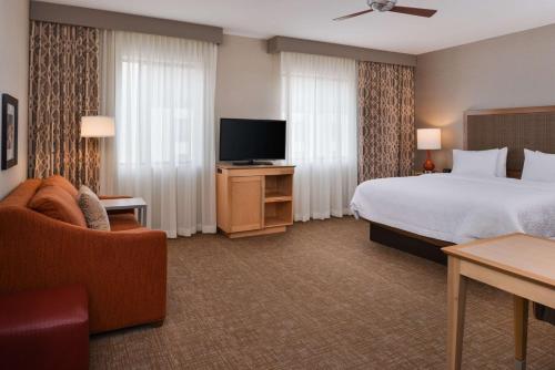 a hotel room with a bed and a television at Hampton Inn & Suites Denver-Speer Boulevard in Denver
