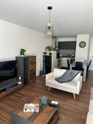 een woonkamer met een witte bank en een tafel bij Luxu’rooms in Lignières