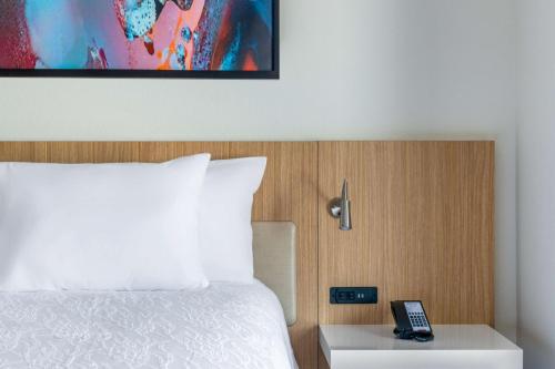 a hotel room with a bed and a phone on a table at Hilton Garden Inn Longmont in Longmont