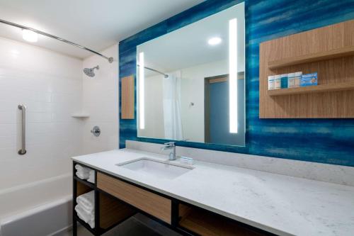 W łazience znajduje się umywalka i lustro. w obiekcie Hilton Garden Inn Longmont w mieście Longmont