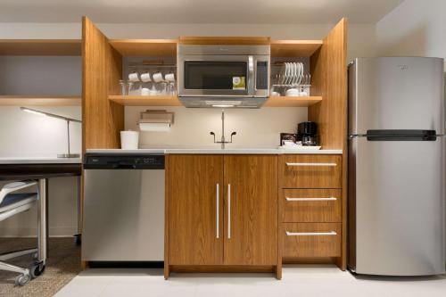 a kitchen with a refrigerator and a microwave at Home2 Suites by Hilton Denver Highlands Ranch in Highlands Ranch