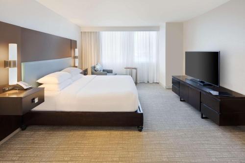 a hotel room with a bed and a flat screen tv at DoubleTree by Hilton Hotel Deerfield Beach - Boca Raton in Deerfield Beach