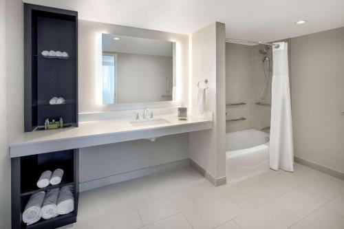 迪爾菲爾德海灘的住宿－迪爾菲爾德海灘博卡拉頓希爾頓逸林酒店，一间带水槽、浴缸和镜子的浴室
