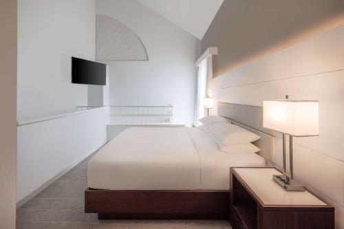 a white bedroom with a bed and a lamp at DoubleTree by Hilton Hotel Deerfield Beach Boca Raton in Deerfield Beach