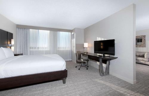a hotel room with a bed and a desk with a television at DoubleTree by Hilton Hotel Deerfield Beach Boca Raton in Deerfield Beach