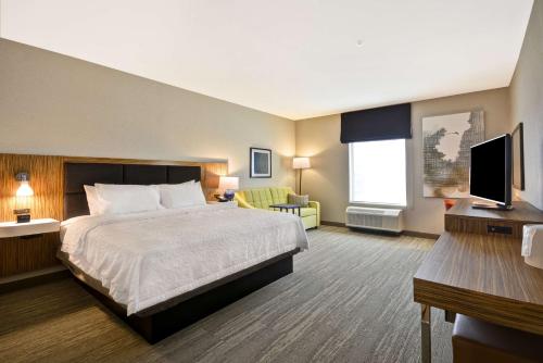 um quarto de hotel com uma cama e uma televisão em Hampton Inn & Suites Detroit/Warren em Warren