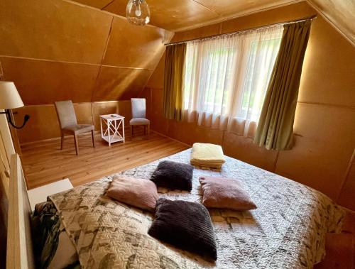 Un dormitorio con una cama grande con almohadas. en Brīvdienu māja Pūces en Līgatne