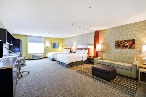 ein Hotelzimmer mit einem Bett und einem Sofa in der Unterkunft Home2 Suites By Hilton Dallas North Park in Dallas