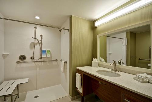 a bathroom with a shower and a sink and a mirror at Home2 Suites By Hilton Dallas North Park in Dallas