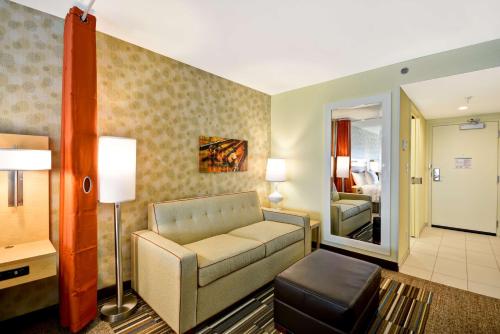 a living room with a couch and a bedroom at Home2 Suites By Hilton Dallas North Park in Dallas