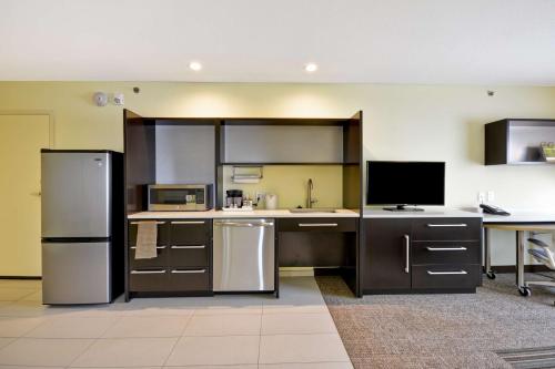 a kitchen with stainless steel appliances and a desk at Home2 Suites By Hilton Dallas North Park in Dallas