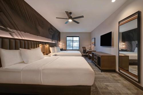 a hotel room with two beds and a television at Homewood Suites by Hilton Dallas The Colony in The Colony