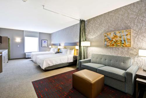 una camera d'albergo con letto e divano di Home 2 Suites By Hilton Fairview Allen a Fairview