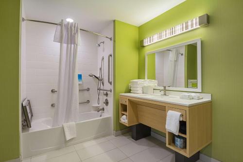 y baño con bañera, lavamanos y ducha. en Home2 Suites By Hilton Dallas Grand Prairie, en Grand Prairie