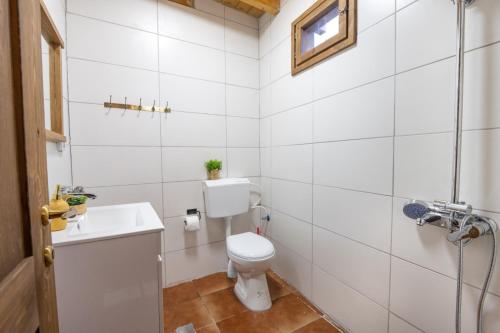 a white bathroom with a toilet and a sink at לומינוס הגפן in Ḥurfeish