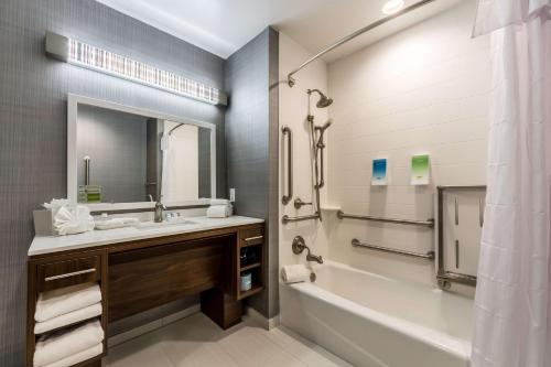 ein Badezimmer mit einem Waschbecken, einer Badewanne und einem Spiegel in der Unterkunft Home2 Suites By Hilton Fort Worth Northlake in Roanoke