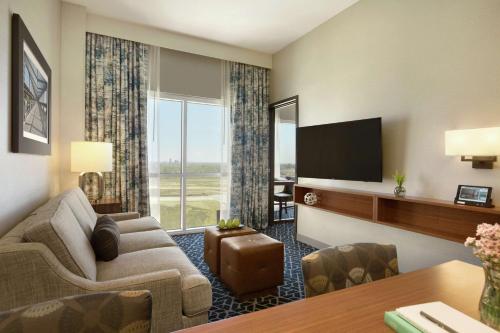 a living room with a couch and a flat screen tv at Embassy Suites By Hilton Denton Convention Center in Denton