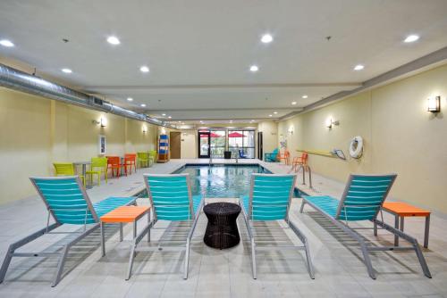 a pool room with chairs and a table and a pool at Home2 Suites By Hilton Fort Worth Southwest Cityview in Fort Worth