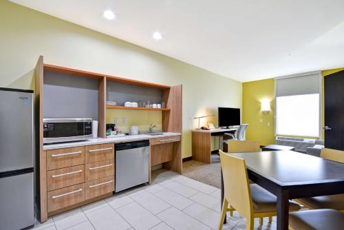 a kitchen with a table and a dining room at Home2 Suites By Hilton Fort Worth Southwest Cityview in Fort Worth