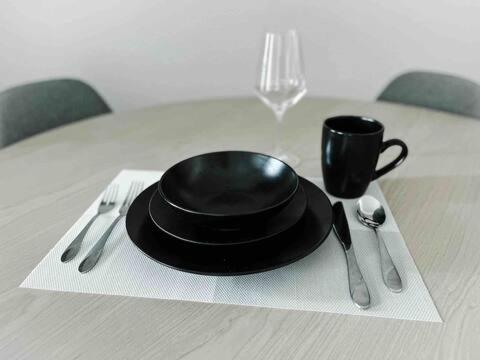 a black plate and a cup on a table at Condo Unit in BGC Taguig Manila with FREE Covered Parking & WiFi in Manila