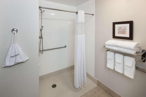 ein Bad mit einer Dusche und weißen Handtüchern in der Unterkunft Hampton Inn & Suites Dothan in Dothan