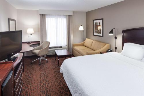 ein Hotelzimmer mit einem Bett und einem Flachbild-TV in der Unterkunft Hampton Inn & Suites Dothan in Dothan