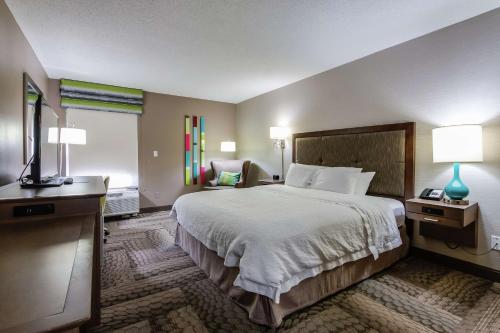 迪克森的住宿－迪克森漢普頓酒店，酒店客房带一张大床和一把椅子