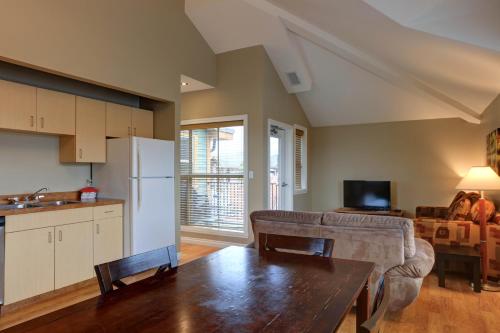 a kitchen and living room with a table and a refrigerator at Vedder River Inn in Chilliwack