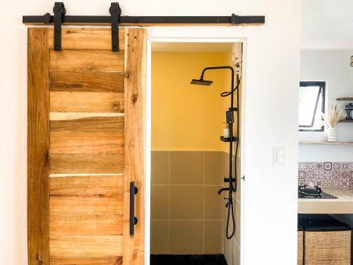 a bathroom with a wooden door in a kitchen at Casa Talisay in General Luna