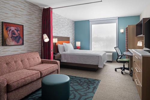 a hotel room with a bed and a couch at Home2 Suites by Hilton Des Moines at Drake University in Des Moines