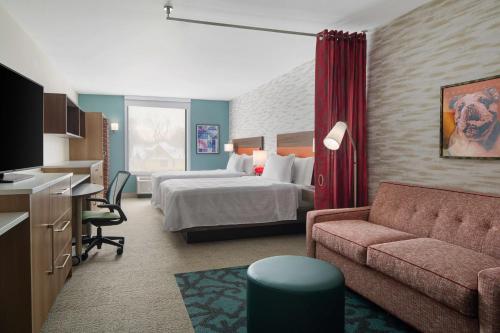 una camera d'albergo con letto e divano di Home2 Suites by Hilton Des Moines at Drake University a Des Moines