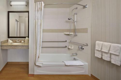 Hilton Garden Inn Danbury في دانبري: حمام مع حوض استحمام ومغسلة