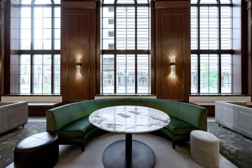 a living room with a green couch and a table at Hotel Fort Des Moines, Curio Collection By Hilton in Des Moines