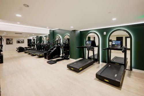 a gym with a row of treadms and elliptical machines at Hotel Fort Des Moines, Curio Collection By Hilton in Des Moines