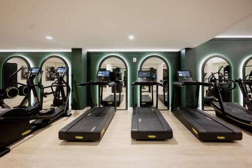 a gym with several treadmills and elliptical machines at Hotel Fort Des Moines, Curio Collection By Hilton in Des Moines