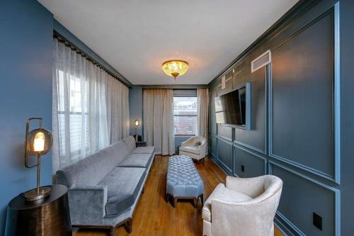 a living room with a couch and chairs and a tv at Hotel Fort Des Moines, Curio Collection By Hilton in Des Moines