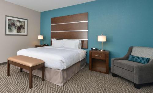 a hotel room with a bed and a chair at Hampton Inn & Suites Des Moines Downtown in Des Moines