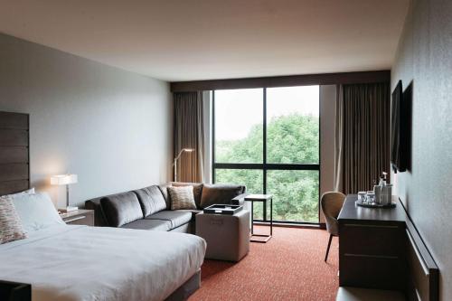 een hotelkamer met een bed en een bank bij Revel Hotel, Tapestry Collection By Hilton in Urbandale