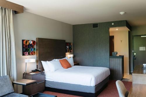 a hotel room with a bed and a chair at Revel Hotel, Tapestry Collection By Hilton in Urbandale