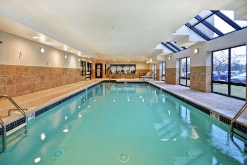 a swimming pool with blue water in a building at Hampton Inn & Suites Detroit-Canton in Canton