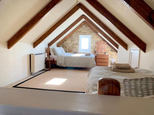 a attic room with two beds in a room at The Post House in Charlestown