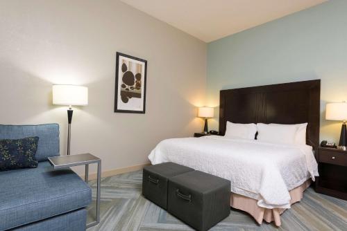 een hotelkamer met een bed en een bank bij Hampton Inn Detroit Roseville in Clinton