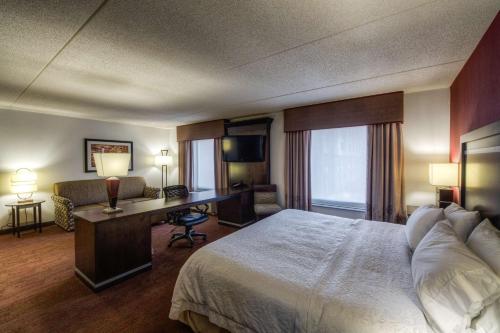 a hotel room with a bed and a desk at Hampton Inn & Suites Detroit/Airport Romulus in Romulus