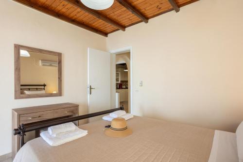 a bedroom with a bed with a mirror and a hat on it at Villa Elia in Nisakion