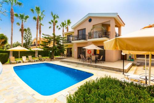 a villa with a swimming pool in front of a house at Villa Halima Alexandros in Polis Chrysochous