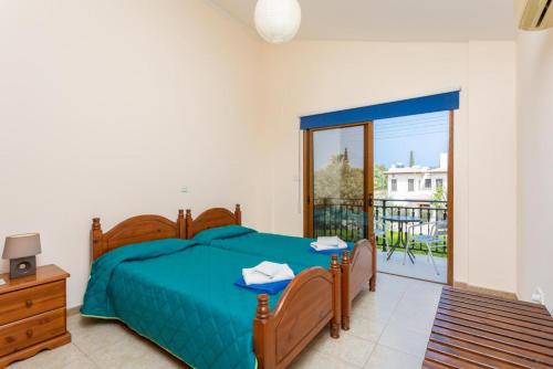 Un dormitorio con una cama azul y un balcón. en Villa Halima Alexandros, en Polis Chrysochous