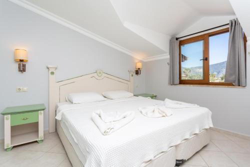 a white bedroom with a white bed and a window at Villa Melek Paradise in Dalyan