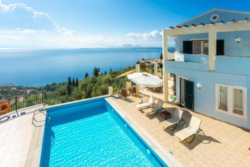 een villa met een zwembad en uitzicht op de oceaan bij Villa Georgios in Plátonas
